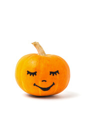 A ripe orange pumpkin with a painted face isolated on a white background.