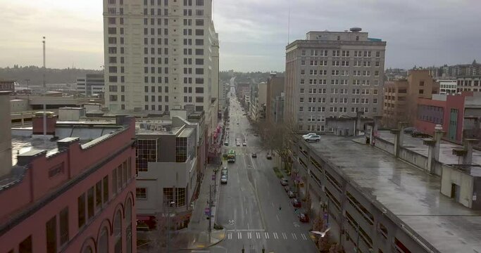 Drone Flying Above The Street In Pacific Ave. In Downtown Tacoma With Modern Buildings Alongside - aerial