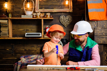 Father teaching little son to use Carpenter tools, screwdriver and screw.