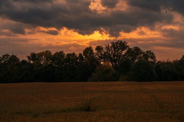 This scenic image shows a sunset over remote rural fields.