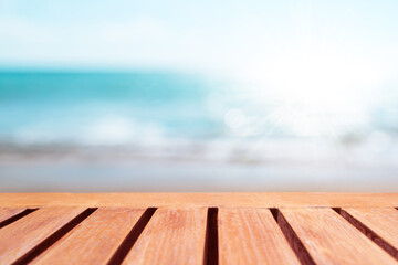 Fototapeta na wymiar Selective focus of old wood table with beautiful beach background for display your product.