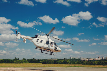 A white helicopter takes off from the runway
