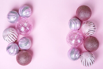 Fototapeta premium Christmas flat lay composition. Set of Christmas pink decorations, shiny balls on pastel background. Mock up for new year gretting card. Copy space for text or lettering