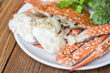 Crab meat - Cooked crab claws and legs on white plate and seafood sauce on the table , blue swimming crab