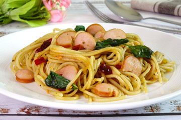 Spaghetti with chili, basil leaves and sausage