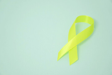 Yellow ribbon Sarcoma Awareness concept on blue background