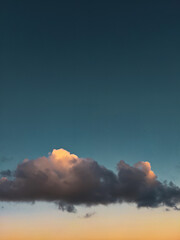 A piece of cloud flowing in the sky with a sunset background