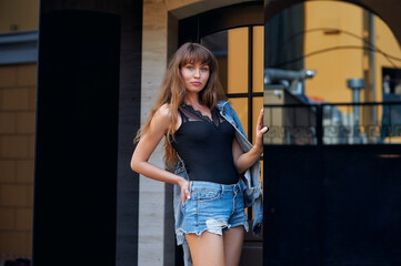 Portrait of a young woman in denim shorts in the city