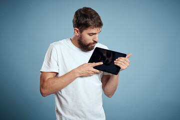 man with tablet near face on blue background cropped view touch monitor new technologies Copy Space