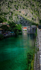 Emerald green waters of Kotor Bay or Boka Kotorska and the ancient wall of Kotor former Venetian fortress in Montenegro