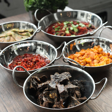 indonesian cuisine, traditional indonesian food, paru goreng or fried beef lungs with side dish on wood background, sundanese food, culinary. Selective focus.