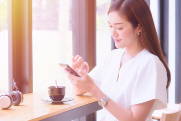 Young girl enjoy using smartphone sitting at modern workplace coffeeshop