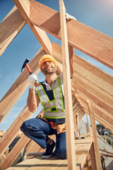 Delighted male person looking upwards at beam