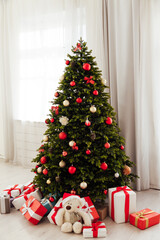 Winter Christmas tree pine with gifts new year decor garland interior of the holiday home December