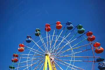carousel ferris wheel on blue sky background