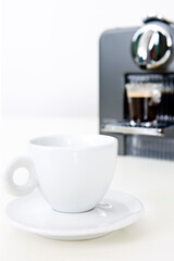 espresso on coffee maker and coffee cup