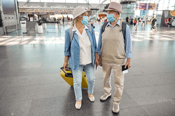 Senior Caucasian travelers holding their boarding tickets