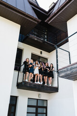 Bride and bridesmaids celebrating bachelorette party. Females friends drinking champagne on the balcony. Happy girls with veil. Maiden evening, Hen-parties. Close up. Place for text.