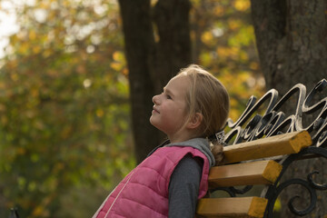 
child in autumn park. autumn foliage. girl walking in autumn park