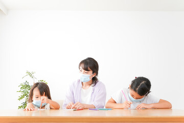 マスクを付けて勉強をする子供と塾講師