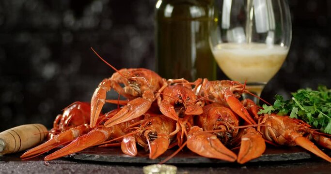 Boiled crayfish and pouring beer into a glass. 