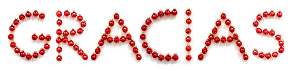 Red Christmas Ball Ornament Building Spanish Word Gracias Means Thank You. Festive Christmas Decoration. White Isolated Background