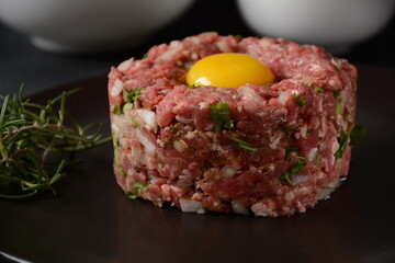 Beef tartare with raw egg,  and onions, fresh herbs. French cuisine