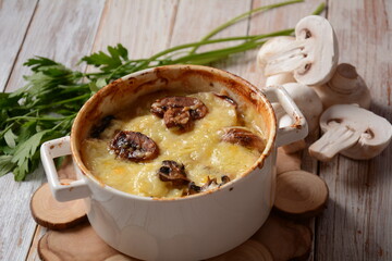 Potato gratin with mushrooms in baking cocottes