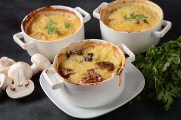 Potato gratin with mushrooms in baking cocottes