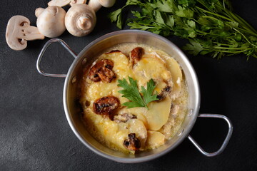 Potato gratin with mushrooms in casserole pan