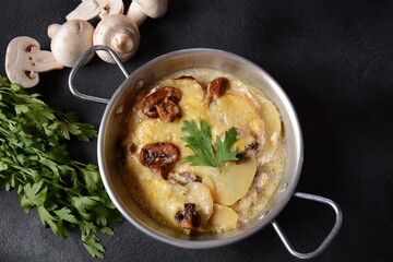 Potato gratin with mushrooms in casserole pan