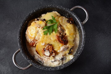 Potato gratin with mushrooms in casserole pan