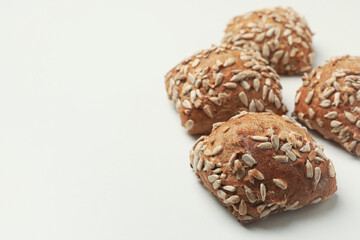 Fresh baked buns with sunflower seeds on white background