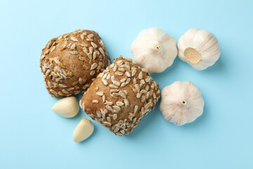Buns with sunflower seeds and garlic on blue background