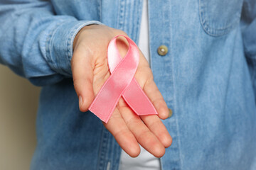 Woman hold pink awareness ribbon, close up
