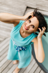 Obraz premium Portrait of brunette woman with short hair looking at camera. Woman wearing blue dress.