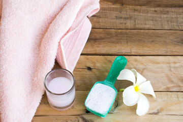 powdered detergent with medicinal liquid solution cleaning health care clothes and white flower frangipani arrangement flat lay style on background wooden