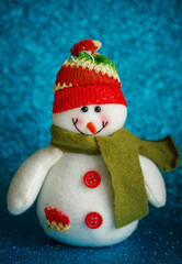 Snowman toy on blue background. New Year decoration