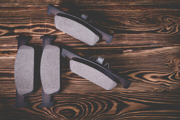 Studio photo of new car brake pads on a wooden background.