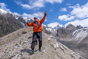 A man and dog at the level of glaciers. Very happy with the beautiful nature and mountains around him