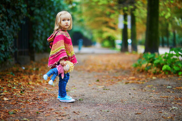 Fototapeta premium Adorable toddler girl walking in park on a fall day in Paris, France