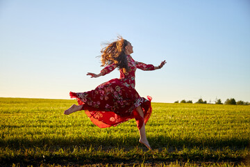 Beautiful woman or girl with magnificent figure and plastic movements walking and dancing in green...