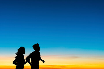Fototapeta na wymiar Silhouette of a couple running and jogging an outdoor workout with morning sky atmosphere natural background.