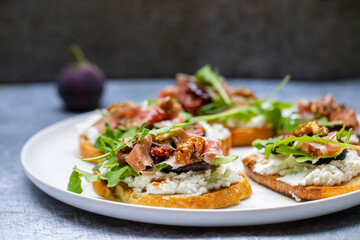 Canapes with ricotta cheese, figs, walnuts and parma ham