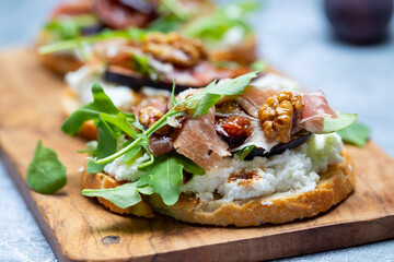 Canapes with ricotta cheese, figs, walnuts and parma ham