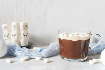 Christmas cocoa with marshmallows on a gray background with white Christmas balls.