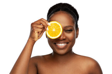 beauty, skin care and detox concept - beautiful smiling african american woman making eye mask of...