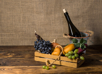 cheeses, sausage, sujuk, a bunch of blue grapes, a bunch of green grapes in a box, a bottle of wine...