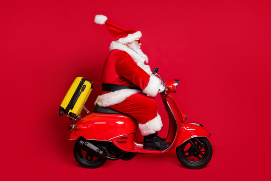 Hurry vacation. Full length profile photo of retired grandpa white beard ride fast vintage moped bag free weekend wear santa x-mas costume coat sunglass cap isolated red color background