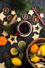 hot tea in a red mug in a new year's atmosphere. Christmas morning. A mug with a drink next to Christmas tree branches, oranges, spices and cookies